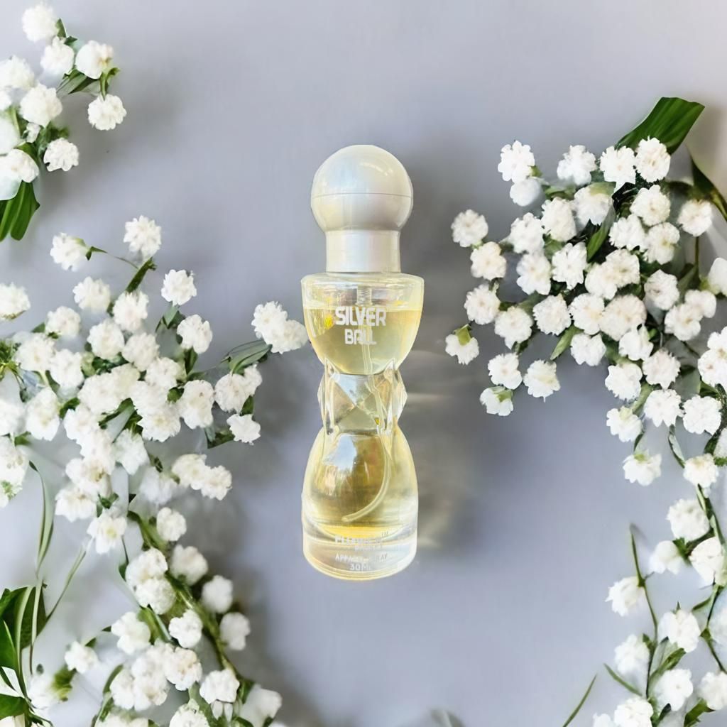 Perfume bottle labeled 'Silver Bell' surrounded by white flowers on a light gray background