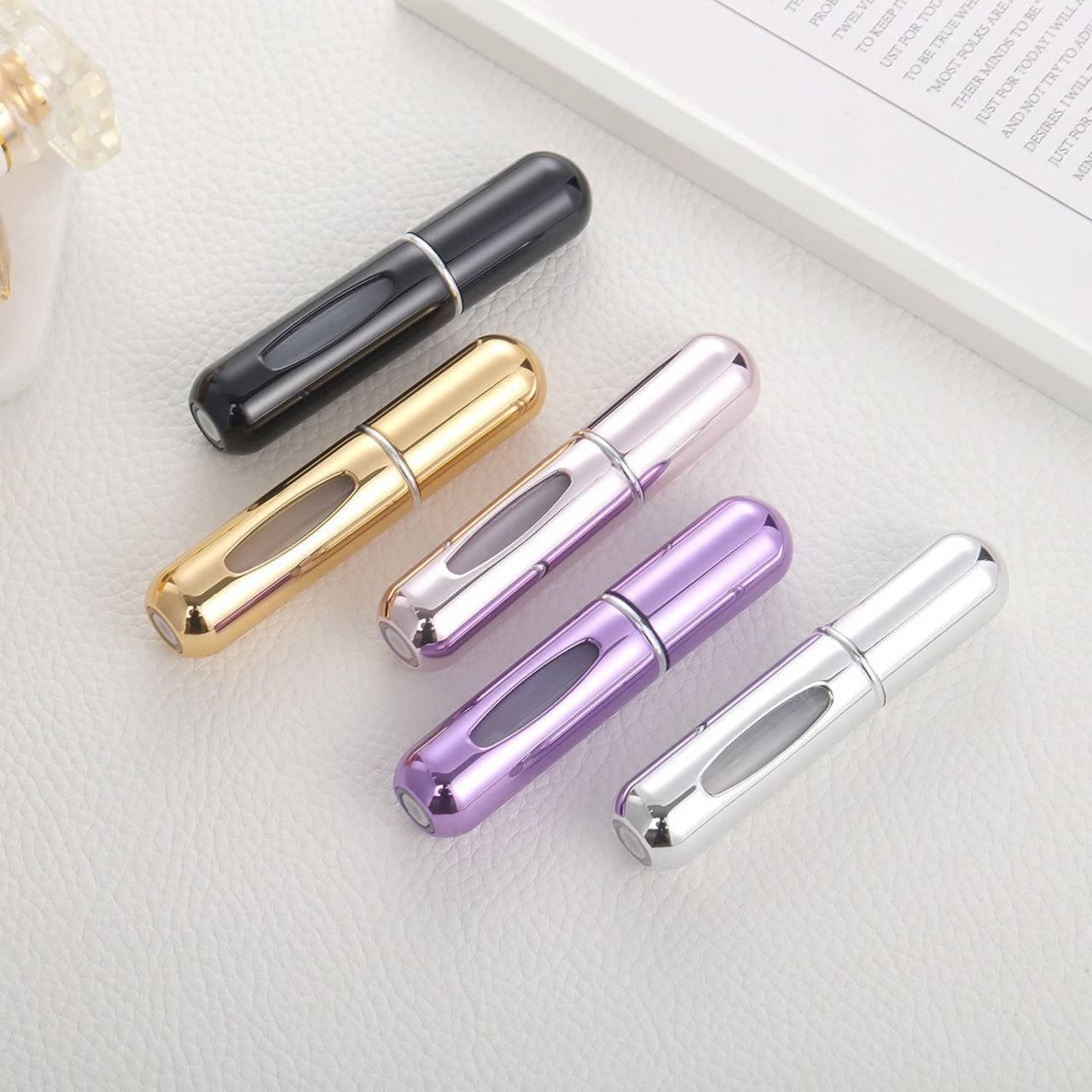 Five metallic pen caps in black, gold, silver, purple, and pink on a white surface.